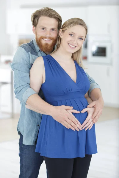 年轻快乐的怀孕夫妇拥抱 — 图库照片