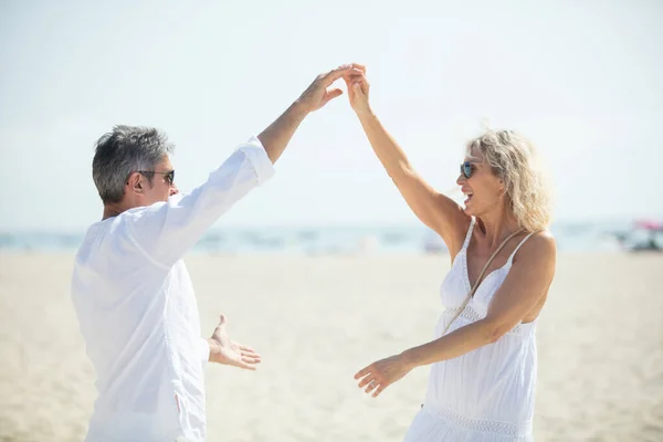 阳光明媚的日子在海滩上跳舞的年长夫妇 — 图库照片