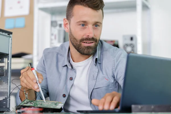Techniker Schaut Auf Laptop Während Einen Computer Repariert — Stockfoto