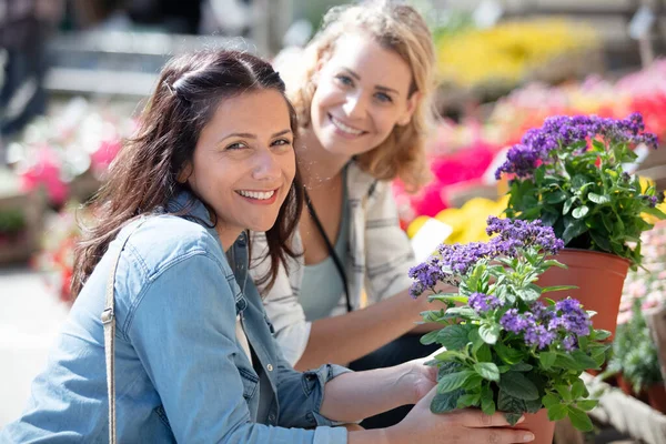 鉢植えの花を買う幸せな女性 — ストック写真