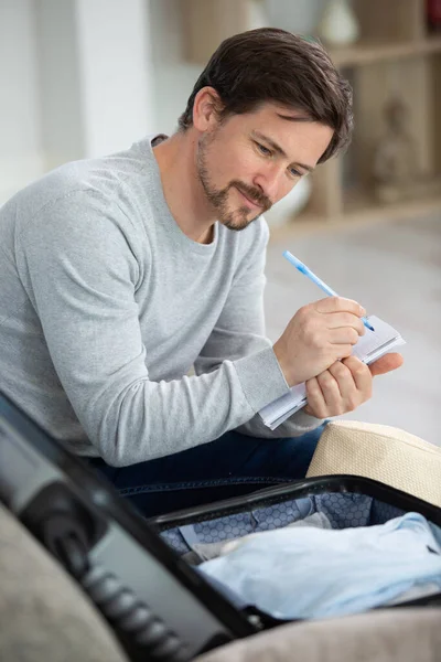 Young Man Taking Notes Packing Preparation Travel Suitcase — Stock Photo, Image