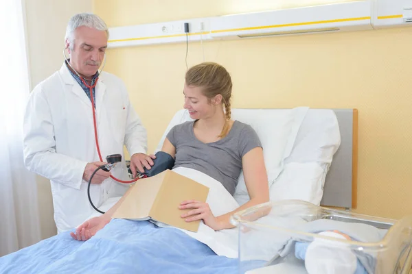 男性医師眼圧計で妊娠中の女性の血圧を測定 — ストック写真
