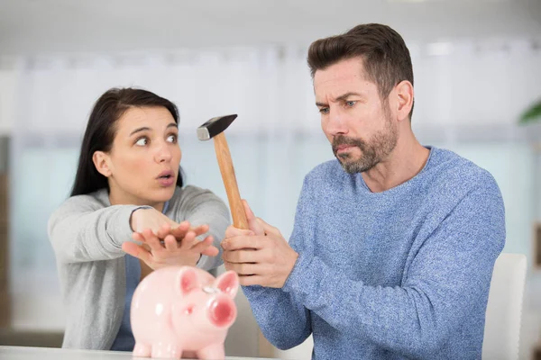 Woman Stopping Husband Breaking Piggy Bank — Stock Photo, Image