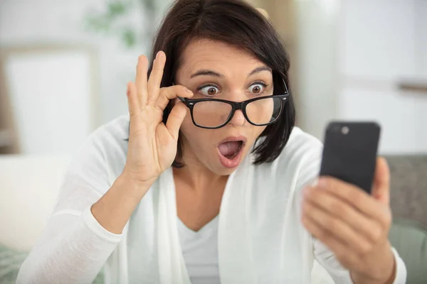 Geschokt Jonge Vrouw Kijken Naar Mobiele Telefoon Thuis — Stockfoto