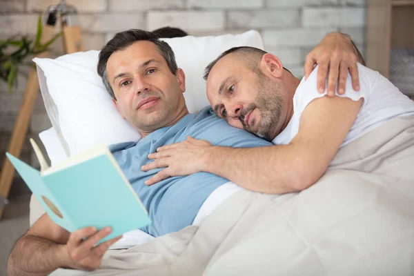 Avslappnad Ung Gay Par Läsa Bok Soffan Hemma — Stockfoto