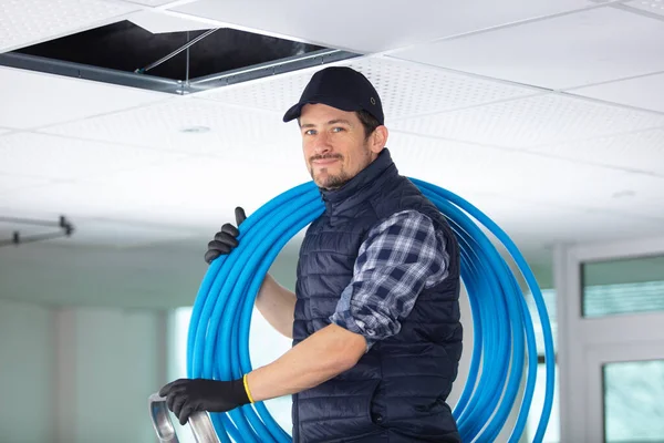 Male Builder Holding Reel Blue Pipe — Stock Photo, Image