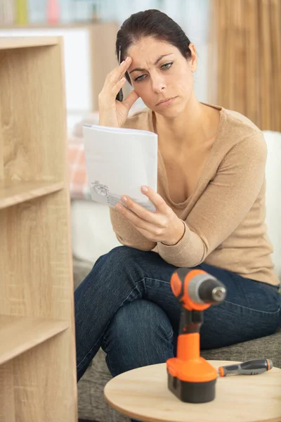 woman reading instructions for assembling furniture