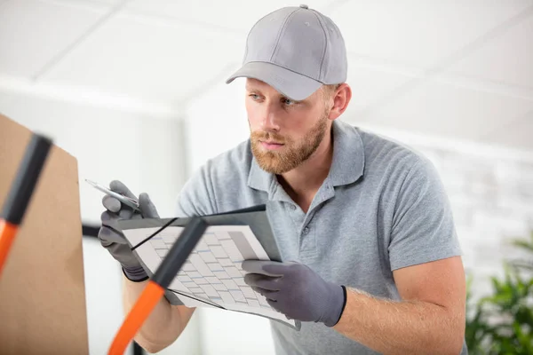 Delivery Man Checking List Clipboard Indoors — Stock Photo, Image