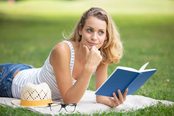 Genç Güzel Bir Kız Kitabı Yeşil Çimlerin Üzerinde Yatıyor — Stok fotoğraf