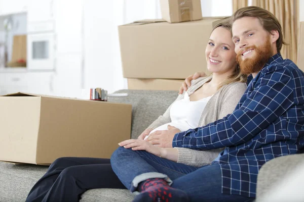 Couple Expecting Baby Sat Sofa Surrounded Cardboard Boxes — Stock Photo, Image