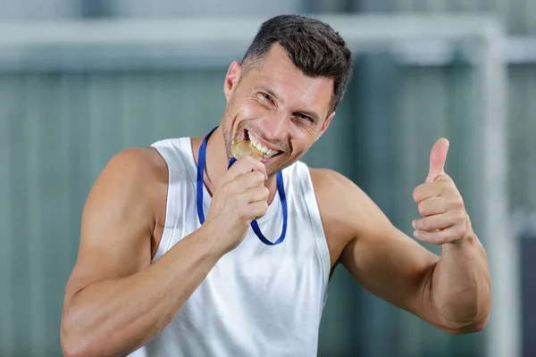 スポーツマンがメダルを噛んだり親指を立てたり — ストック写真