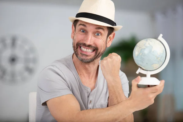 Happy Man Holding Small Globe Home — Stock Photo, Image