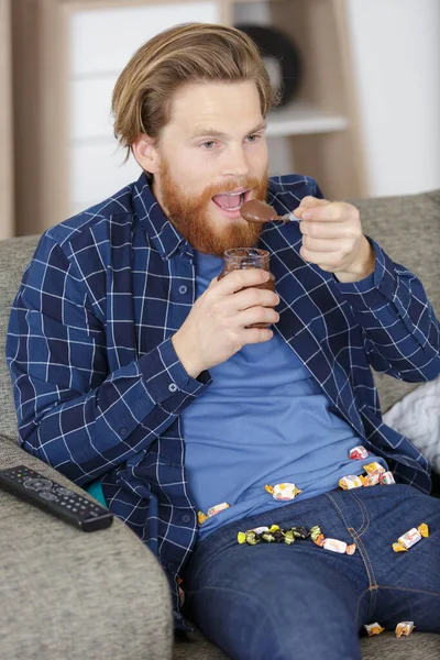 男は喜びを持ってチョコレートを食べる — ストック写真