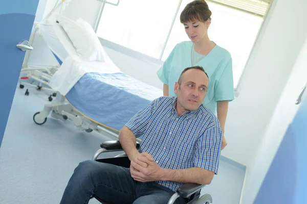 护士推着病人坐轮椅住院 — 图库照片