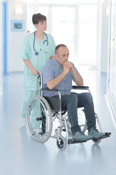 Pielęgniarka Biorąca Pacjenta Wózku Inwalidzkim Korytarzu Szpitalnym — Zdjęcie stockowe