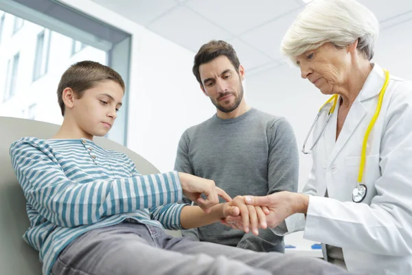 Médico Examina Criança Com Uma Lesão Mão — Fotografia de Stock