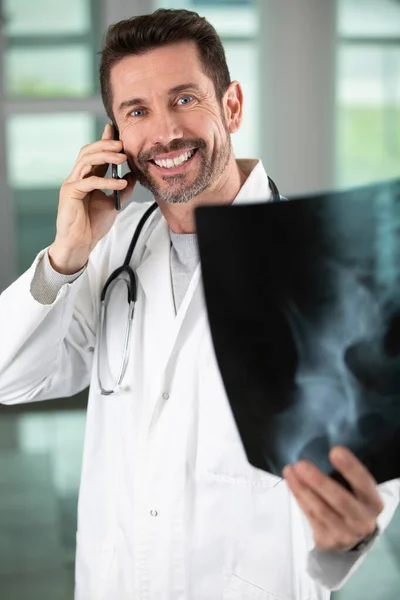 X線を持っている電話の幸せな男性医師は — ストック写真