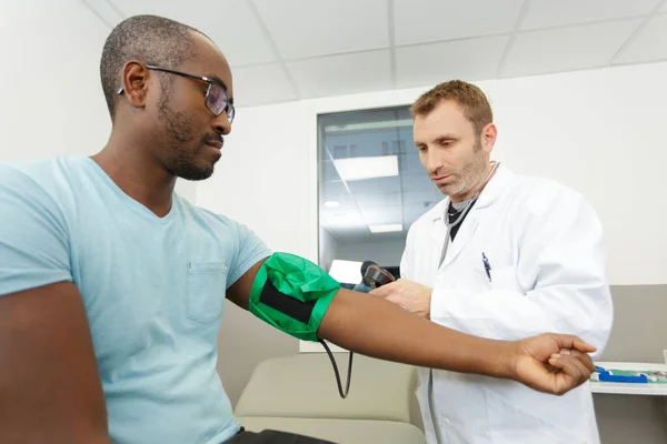 Manlig Läkare Som Tar Man Blodtryck — Stockfoto
