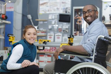 disabled worker in wheelchair in a carpenters workshop clipart