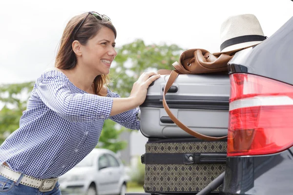 Женщина Пытается Засунуть Чемодан Багажник Своей Машины — стоковое фото