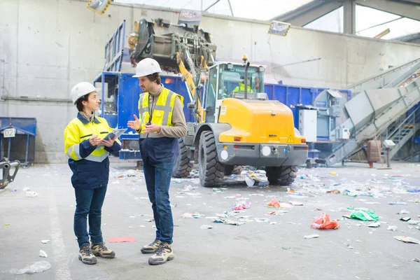 两名工人在回收中心谈话 — 图库照片