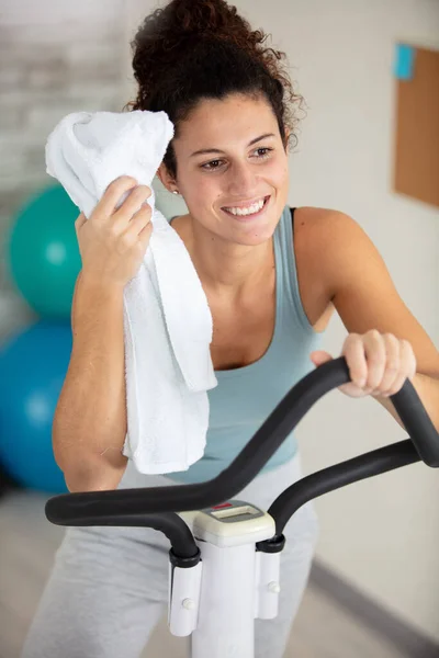 smiling young woman with towel after exercising at home