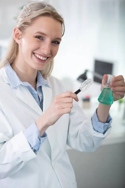 female scientist analyzes liquid in the beaker