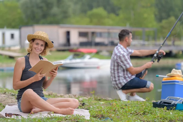 Women Reading While Boyfriend Fishing — Stock Photo, Image