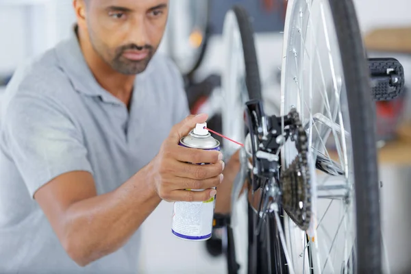 Trabalhador Masculino Lubrificando Uma Cadeia Bicicletas Com Spray Óleo — Fotografia de Stock