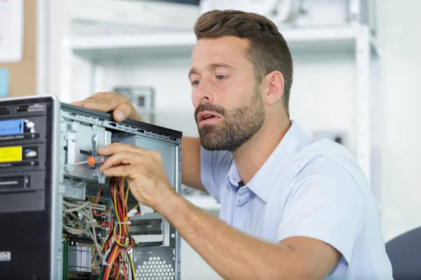 male worker fixing a computer plugin