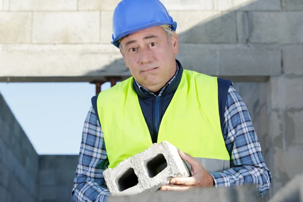 Unsure Builder Carrying Heavy Building Block — Stock Photo, Image