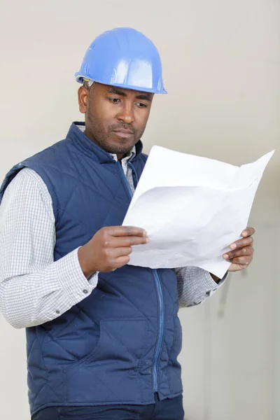 project-manager looking at paperwork inside a property