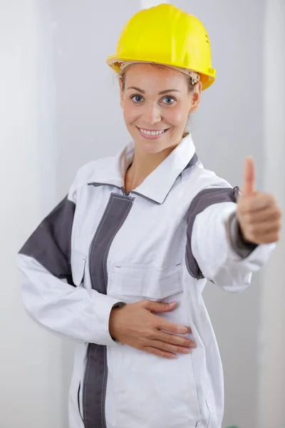 Sarı Miğferli Gülümseyen Kadın Inşaatçı Başparmağını Kaldırıyor — Stok fotoğraf