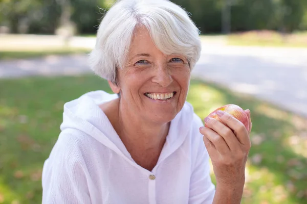 Glad Mogen Kvinna Håller Äpple När Står Parken — Stockfoto