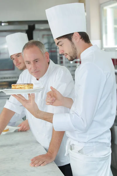 pastry chef and apprentice working at kitchen