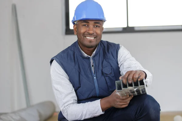 Builder Crouching Open Pack Metal Parts — Stock Photo, Image