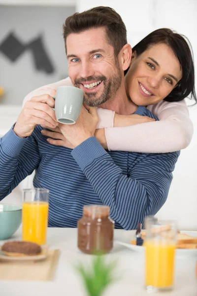 Mujer Abrazando Novio Por Mesa Del Desayuno —  Fotos de Stock