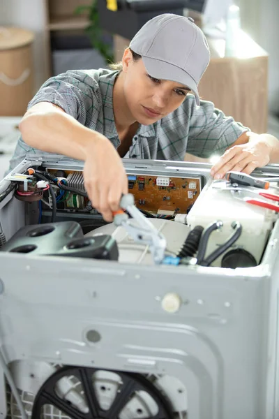 woman technician repairing washing machine