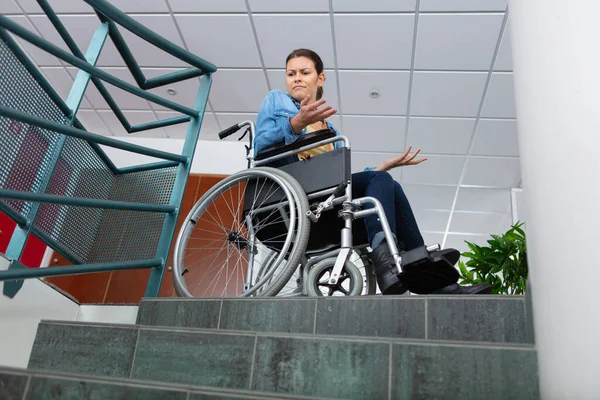 woman on wheelchair standing before stairs