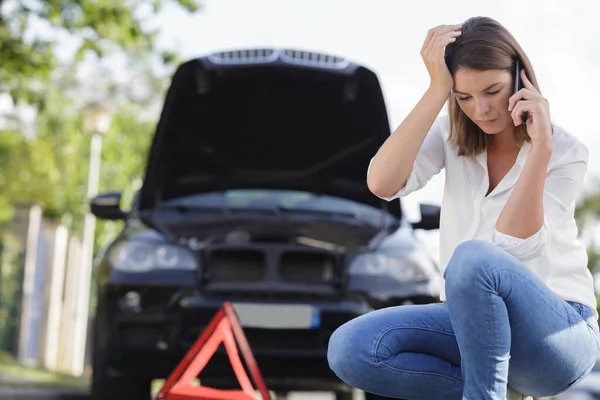 pretty woman having problem with car on the road