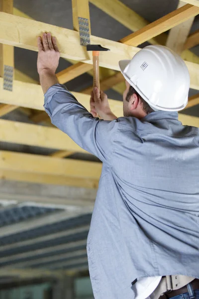 Male Builder Hammers Nail Wooden Structure — Stock Photo, Image