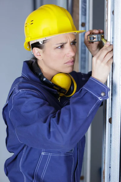 Concentrated Female Builder Measuring Window —  Fotos de Stock