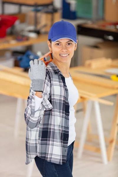 Woman Carpenter Holding Spirit Level —  Fotos de Stock