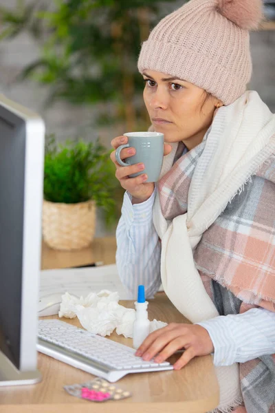 Poorly Woman Wearing Woolly Hat Using Computer — Stockfoto
