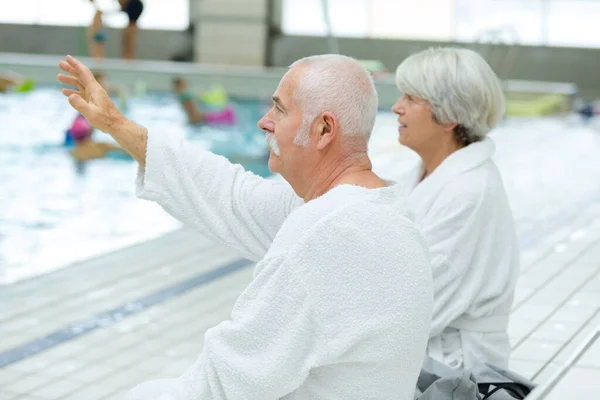 Elderly Couple Lying Waving Someone Pool Deck — Stock Photo, Image
