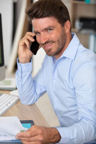 office worker calling on the phone and reading business document