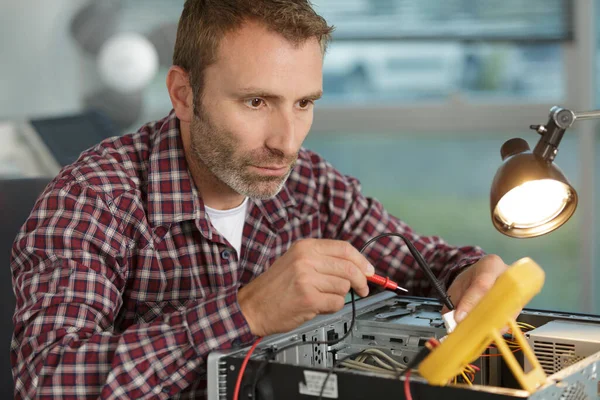 Man Repairing Computer Using Multimeter — Fotografia de Stock