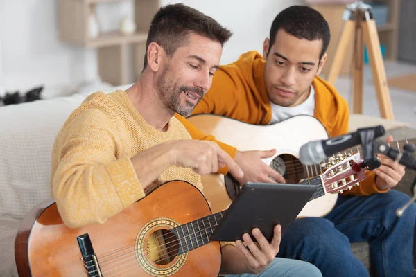 father teaching son the guitar