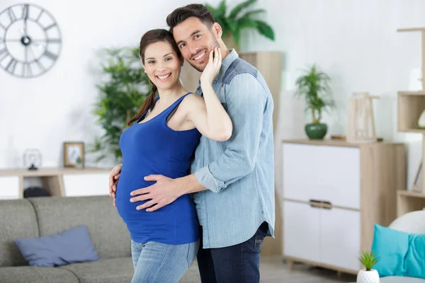 Man Embracing His Pregnant Girlfriend Looking Camera — Stock fotografie