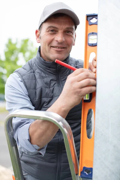 Cheerful Middle Aged Workman Using Spirit Level Stock Kép